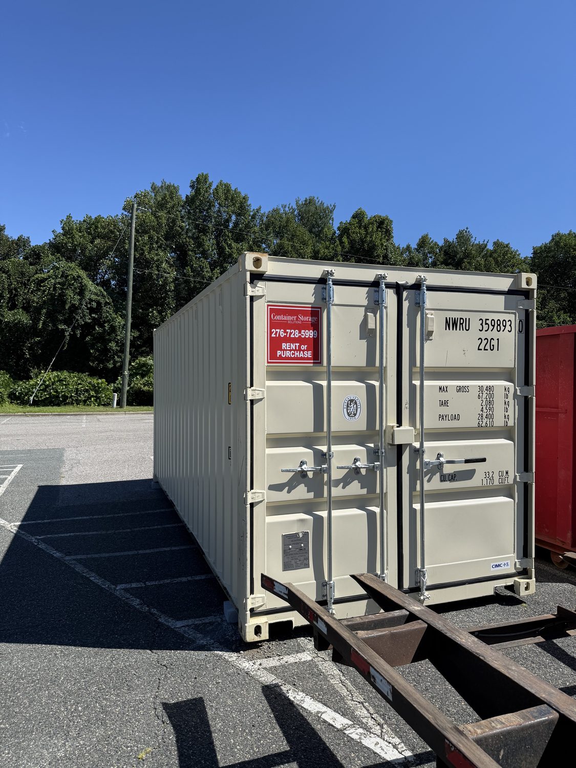 Two shipping containers delivered to a wooded clearing